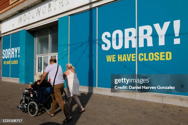 People pass by permanently shuttered businesses amid a wave of high street chain closures brought on by financial strain of the Covid-19 pandemic on...