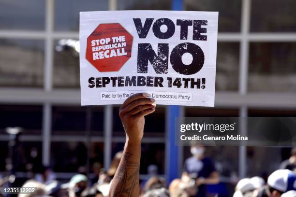 Man holds up a sign at a rally against the recall at Culver City High School on September 4, 2021.