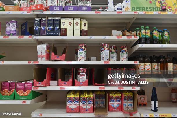 Empty shelves are pictured where fruit juice cartons would normally be stocked inside a Sainsbury's supermarket in London on September 7, 2021. -...