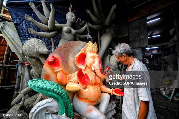 An artist puts the final touches to an idol of Lord Ganesha for the upcoming Ganesh Chaturthi festival at the Artist hub Kumortuli. Ganesh Chaturthi...