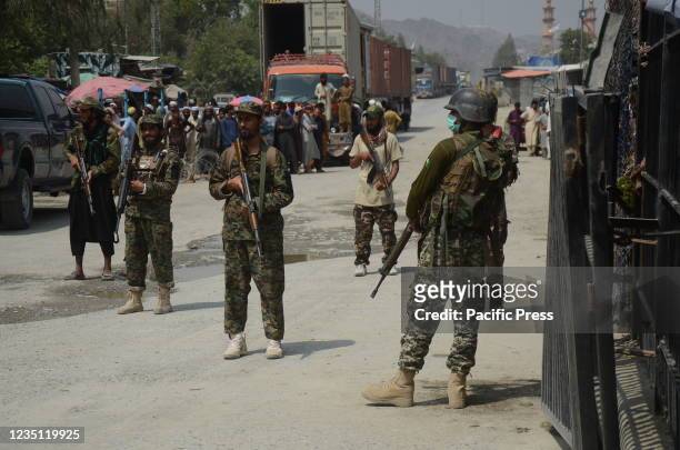 Pakistani paramilitary soldiers and Taliban fighters stand guard on their respective sides, at a border crossing point between Pakistan and...