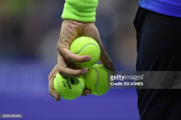 Italy's Matteo Berrettini holds tennis balls as he prepares to serve to Serbia's Novak Djokovic during their 2021 US Open Tennis tournament men's...