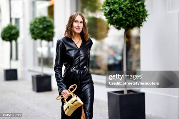 Influencer Annette Weber, wearing a black leather dress by Nanouschka and a gold colored mini bag by Balenciaga and a chain by Ariane Ernst, seen at...