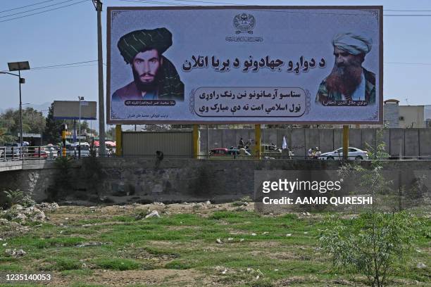 Billboard with the images of late Afghan Taliban leader Mullah Omar and late Afghan leader of the Haqqani network Jalaluddin Haqqani is seen along a...