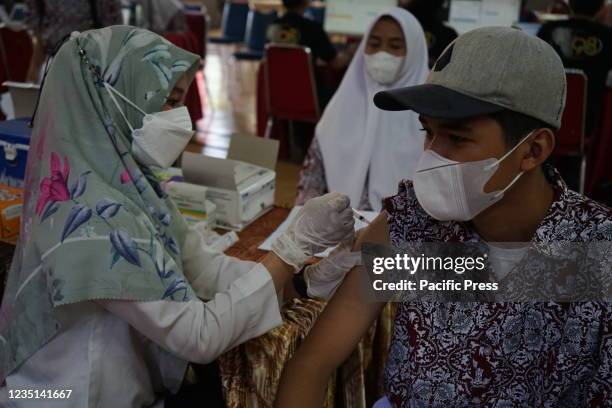 Student in Makassar City receives a dose of Covid-19 vaccine by a health worker at the SMKN 2 Makassar Hall. This Covid-19 vaccination was organized...