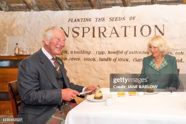 Britain's Prince Charles, Prince of Wales and Britain's Camilla, Duchess of Cornwall are served a traditional Scottish meal of Haggis, neeps and...