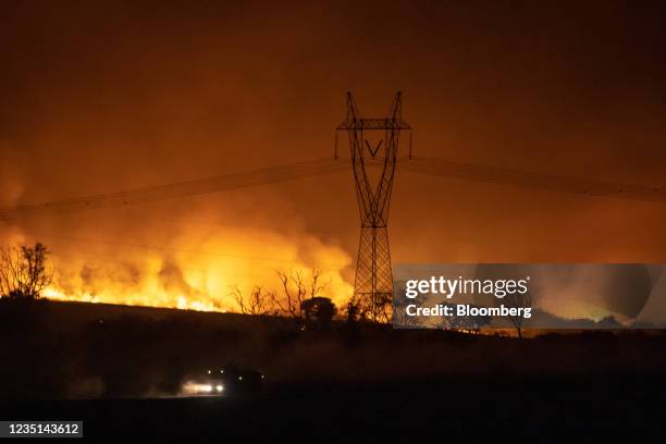 Fire engulfs farm land near a high voltage transmission tower near Ribeiro Preto, Sao Paulo state, Brazil, on Sunday, Aug. 22, 2021. Extreme weather...