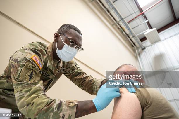 Preventative Medicine Services NCOIC Sergeant First Class Demetrius Roberson administers a COVID-19 vaccine to a soldier on September 9, 2021 in Fort...