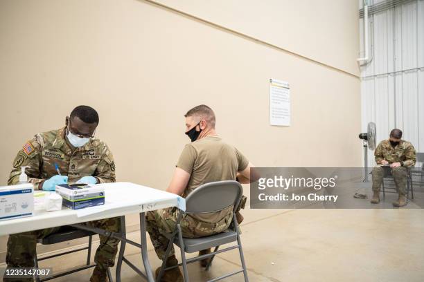 Preventative Medicine Services NCOIC Sergeant First Class Demetrius Roberson prepares to administer a COVID-19 vaccine to a soldier on September 9,...