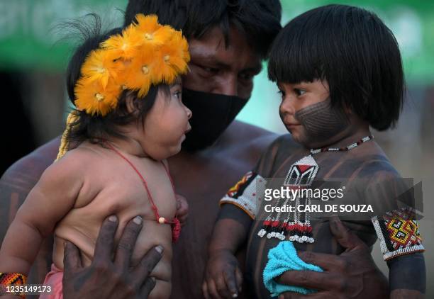 Young boy from the Kayapo tribe is introduced to a young girl from the Krenak tribe at a protest camp in Brasilia, on September 9, 2021. - The...