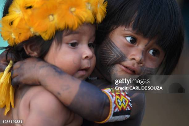 Young boy from the Kayapo tribe hugs a young girl from the Krenak tribe at a protest camp in Brasilia, on September 9, 2021. - The Supreme Federal...