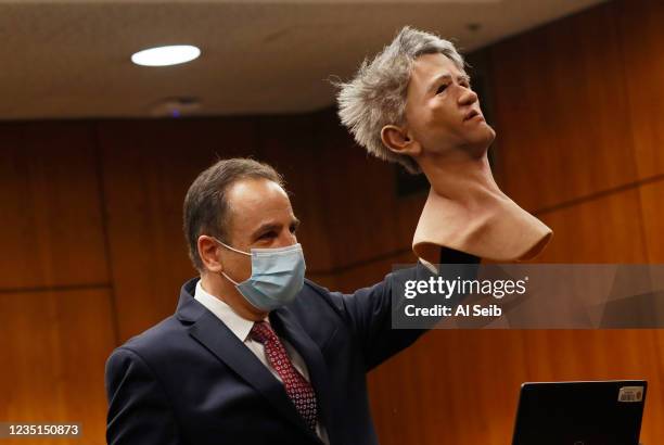 Deputy District Attorney Habib A. Balian holds a rubber latex mask, donned by Robert Durst when police arrested him along with a fake ID and more...