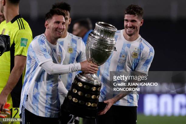 Argentina's Lionel Messi and Argentina's Rodrigo De Paul hold the Copa America trophy while posing for a picture at the end of their South American...