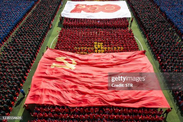 University students display a flag of the Communist Party of China to mark the party's 100th anniversary during an opening ceremony of the new...