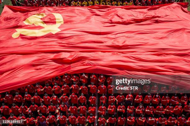 University students display a flag of the Communist Party of China to mark the party's 100th anniversary during an opening ceremony of the new...