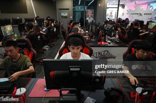 People play computer games at an internet cafe in Beijing on September 10 days after Chinese officials summoned gaming enterprises including Tencent...