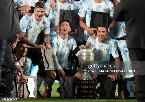 Argentina's Lionel Messi , Angel Di Maria , Rodrigo De Paul and Leandro Paredes pose with teammates with the recently won Copa America trophy at the...