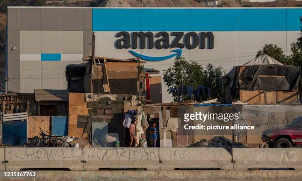 September 2021, Mexico, Tijuana: Amazon's new warehouse stands surrounded by a wall next to a poorer neighborhood. Photo: Stringer/dpa