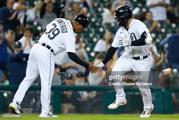 Eric Haase of the Detroit Tigers celebrates with third base coach Ramon Santiago after hitting a solo home run against the Tampa Bay Rays during the...