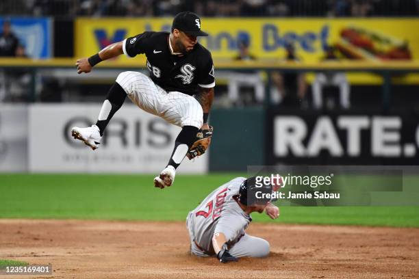 Leury García of the Chicago White Sox leaps and looks back at the ball that was overthrown as Christian Vázquez of the Boston Red Sox steals second...