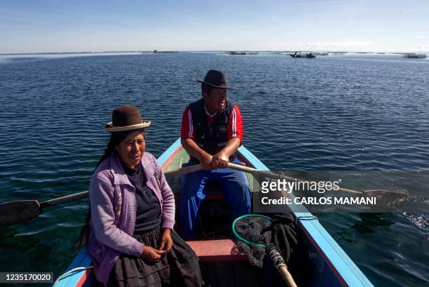 Trout farm business partners Zenobia Rodriguez and Jose Mamani, prepare to harvest mature individuals from a rowboat in Lake Titicaca, off the Aymara...