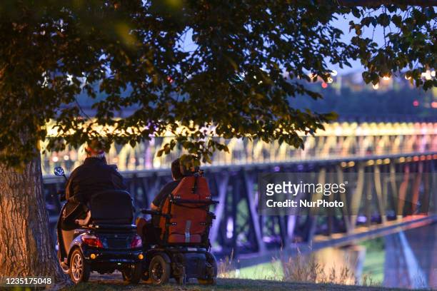 Two wheelchair users observe the illuminated High Level Bridge in Edmonton. Edmontonians participated this evening in the sixth annual Bridge Of Life...