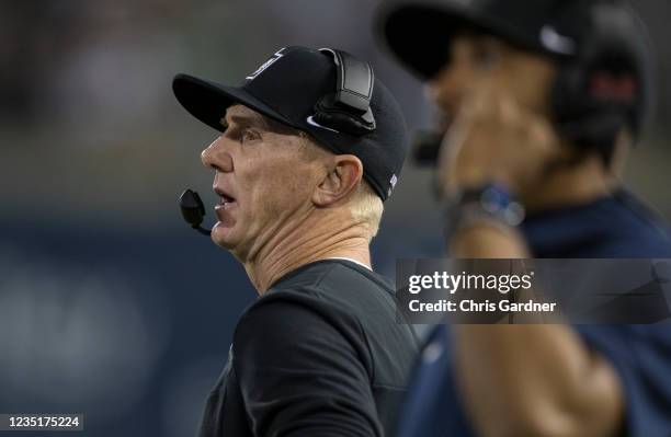 Head coach Blake Anderson of the Utah State Aggies talks in his headset during their game against the North Dakota Fighting Hawks at Maverick Stadium...