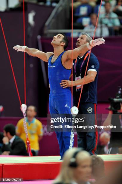 Danell Leyva representing the United States is helped onto the rings by his coach and stepfather Yin Alvarez in the mens artistic individual...