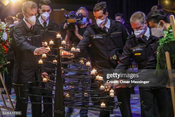 Members of the city fire department light candles as they attend a memorial service at the Kaiser-Wilhelm-Gedächtnis-Kirche church to commemorate...