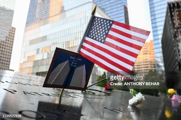An American flag placed along with a photo of the Twin Towers and the name Daniel P. Trant, a Cantor Fitzgerald bond trader that died during 9/11, at...