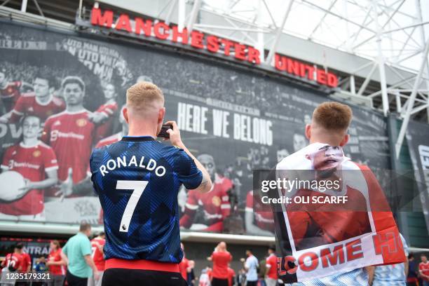 Manchester United fans wearing Cristiano Ronaldo shirts wait outside the ground ahead of the English Premier League football match between Manchester...