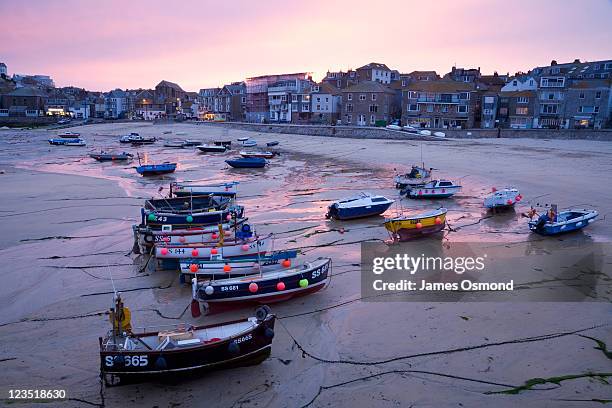 low tide in st. ives harbour at sunset, a traditional fishing town popular with artists on the cornish coast - st ives fotografías e imágenes de stock