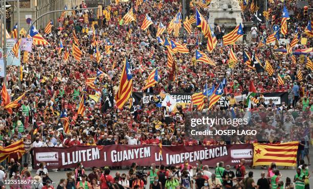 People wave Catalan pro-independence "Estelada" flags during a demonstration marking the "Diada", national day of Catalonia, in Barcelona on...