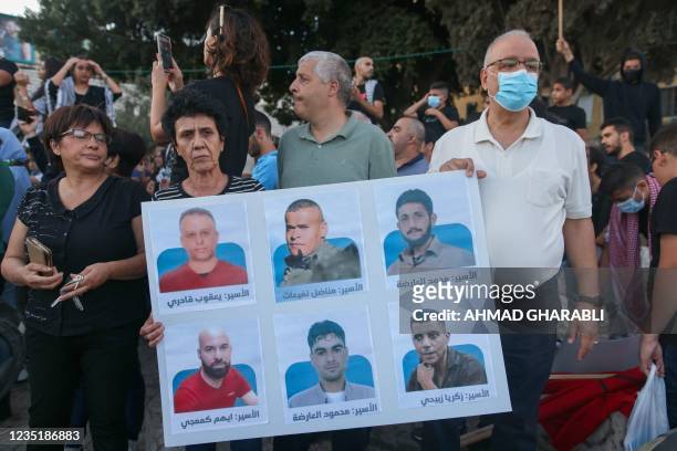 Arab Israeli protesters lift a placard depicting six Palestinian prisoners who escaped from Israel's Gilboa prison, as they demonstrate to support...