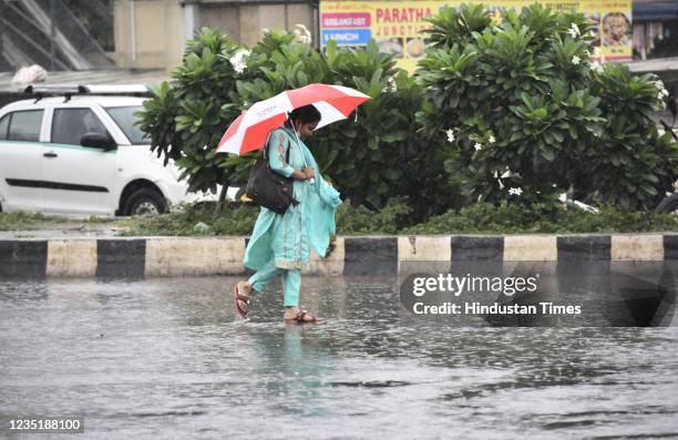 Woman carrying an umbrella walks in a rain at Rajiv Chowk during heavy Monsoon Rain on September 11, 2021 in Gurugram, India. Delhi and its adjoining...