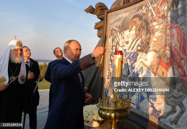 Russian President Vladimir Putin lights a candle unveiling a huge monument to legendary Russian medieval prince Alexander Nevsky in the village of...