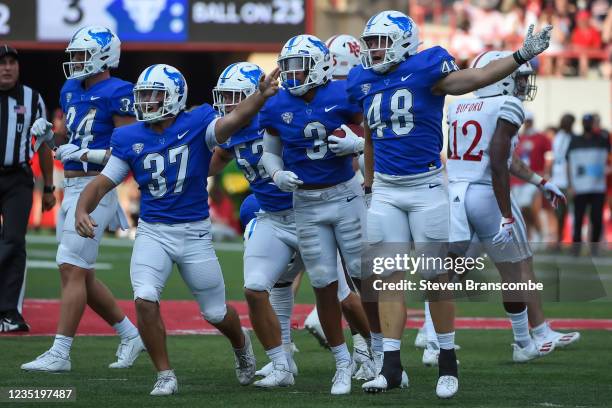 Cornerback Aapri Washington of the Buffalo Bulls celebrates a turnover with linebacker Fabian Weitz and long snapper Evan Davis against the Nebraska...