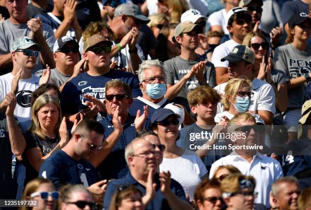 Two Penn State fans are wearing masks and surrounded by fans not wearing masks in the stands during the Ball State Cardinals versus Penn State...