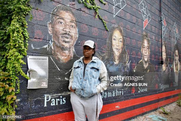 Resident Seditra Brown stands next to a mural depicting her son Paris Brown in Washington, DC, on September 9, 2021. - One by one, Seditra Brown, a...