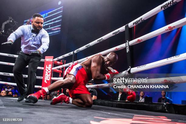 Former professional boxer Evander Holyfield falls during a fight with Brazilian martial artist Vitor Belfort during a boxing fight at Hard Rock Live...