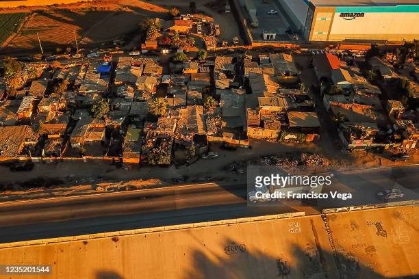 Aerial view around a marginal neighborhood settled next to new Amazon warehouse on September 11, 2021 in Tijuana, Mexico. The 21 million USD...