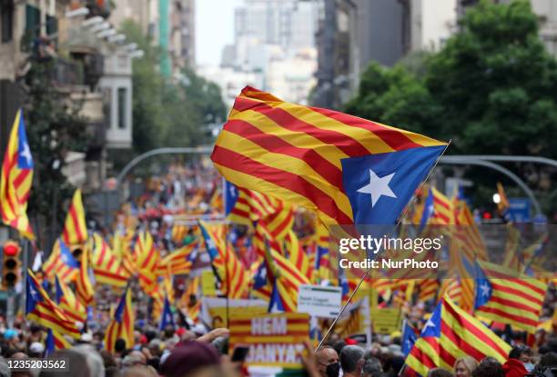 People wave Catalan pro-independence ''Estelada'' flags during a demonstration marking the ''Diada'', national day of Catalonia, in Barcelona on...