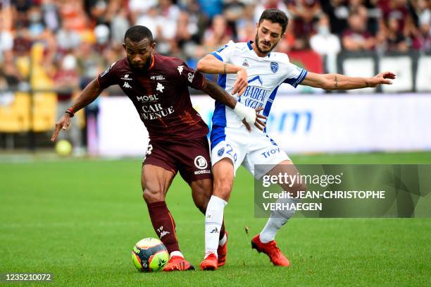 Metz's Ivorian midfielder Habib Maiga vies with Troyes' midfielder Xavier Chavalerin during the French L1 football match between FC Metz and ES...