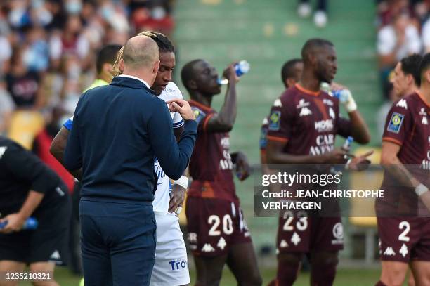 Troyes' Portuguese-Luxembourgian forward Gerson Rodrigues speaks with Troyes's coach Laurent Batlles during the French L1 football match between FC...