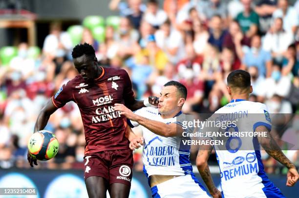 Metz's Senegalese forward Ibrahima Niane fights for the ball with Troyes' French midfielder Karim Azamoum during the French L1 football match between...