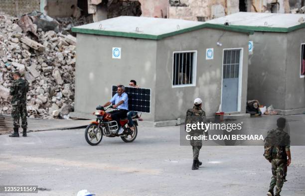 Picture taken during a tour organized by the Syrian Ministry of Information shows Syrian soldiers in front of newly built structures in the district...