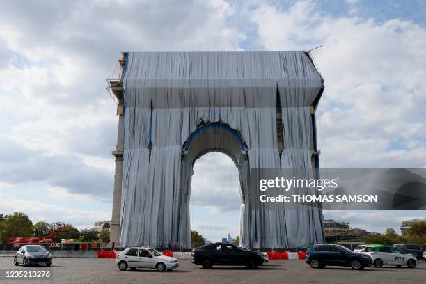 Workers unravel silver blue fabric, part of the process of wrapping L'Arc de Triomphe in Paris on September 12 designed by the late artist Christo. -...