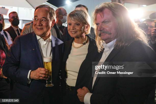 Armin Laschet, leader of the German Christian Democrats and CDU/CSU holds a beer as he stands next to German actress Uschi Glas and the Hungarian...