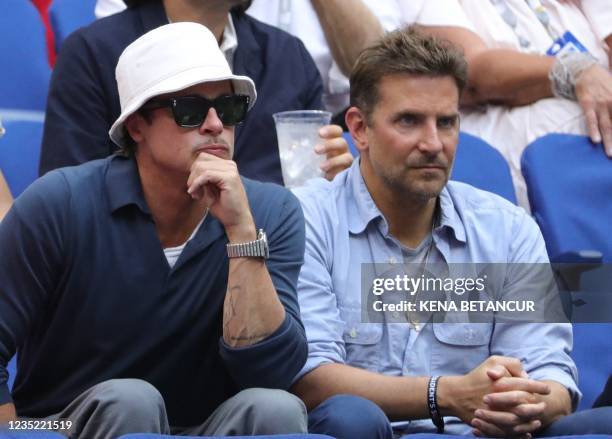 Actors Brad Pitt and Bradley Cooper watch the match between Serbia's Novak Djokovic and Russia's Daniil Medvedev during their 2021 US Open Tennis...