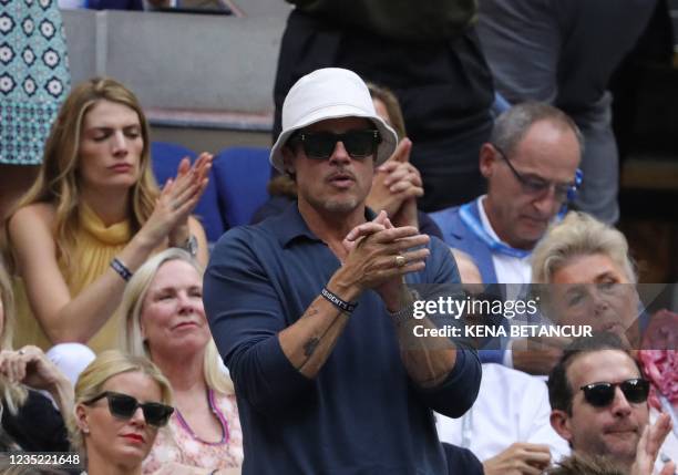 Actor Brad Pitt applauds as he watches the match between Serbia's Novak Djokovic and Russia's Daniil Medvedev during their 2021 US Open Tennis...